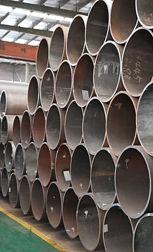 Yellow forklift carrying steel pipes at Kelly Pipe facility